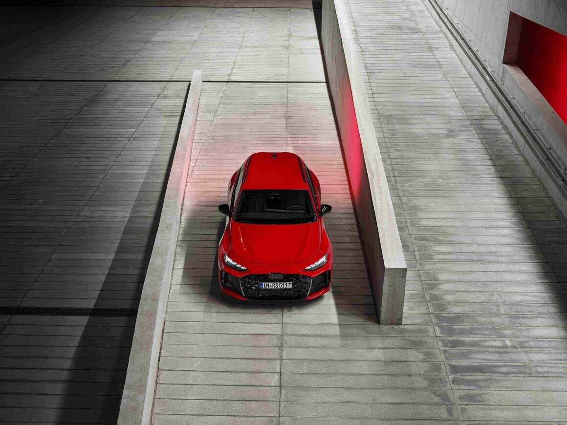Uniek bovenaanzicht van de rode Audi RS5 Avant die een helling in een parkeergarage oprijdt.