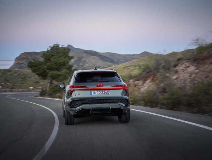 Achteraanzicht van de Audi Q3 2025 in een bochtige bergweg bij zonsopgang
