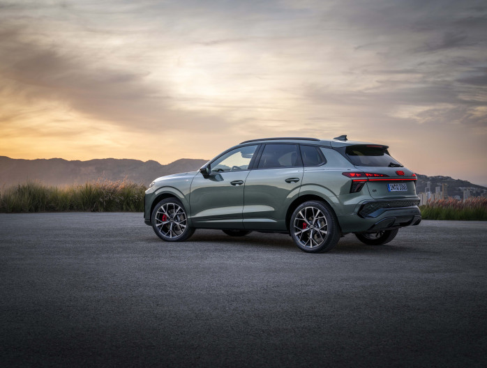 Zijaanzicht van de Audi Q3 2025 bij schemering op een open plek