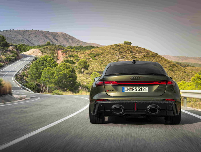 Laag standpunt van de achterkant van de Audi RS5, met focus op de sportieve diffusor en dubbele uitlaten.