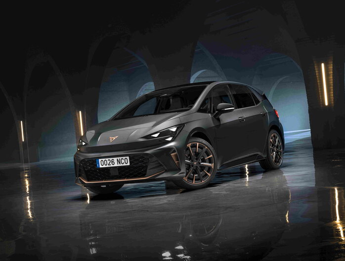 Donkergrijze Cupra Born met koperkleurige velgen en logo in sfeervolle omgeving.