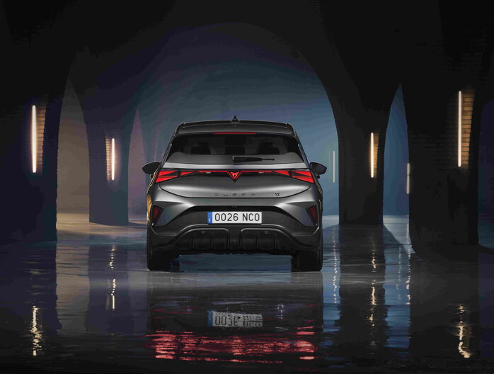 Achterkant van een donkergrijze Cupra Born met opvallende LED-achterlichten in een sfeervolle tunnel.