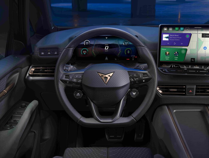 Cupra Born interieur met geperforeerd stuur, digitale schermen en bronskleurige dashboardaccenten.