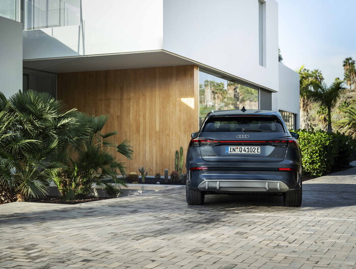 Audi Q4 e-tron geparkeerd op een moderne oprit achteraanzicht