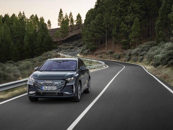 Audi Q4 e-tron rijdend op bosweg vooraanzicht