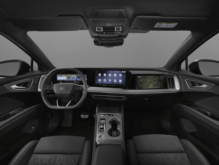 Audi Q4 interieur toont modern digitaal dashboard, groot touchscreen en zwart sportstuur.