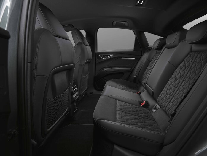 Audi Q4 interieur: luxe zwarte achterbank met stijlvol gestikt ruitpatroon.