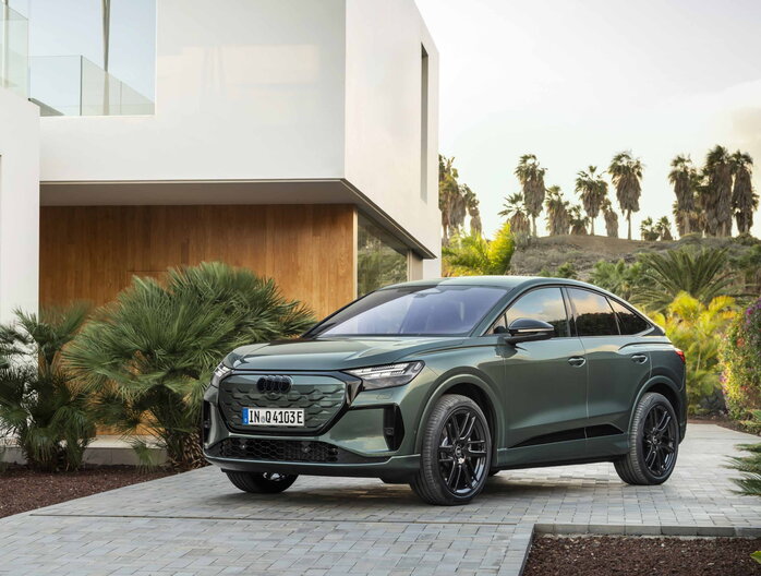Donkergroene Audi Q4 Sportback e-tron elektrische SUV met zwarte velgen buiten.