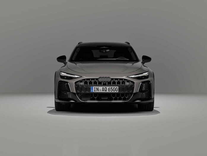 Audi A6 Allroad grijs, strak vooraanzicht met kenmerkende koplampen in studio.