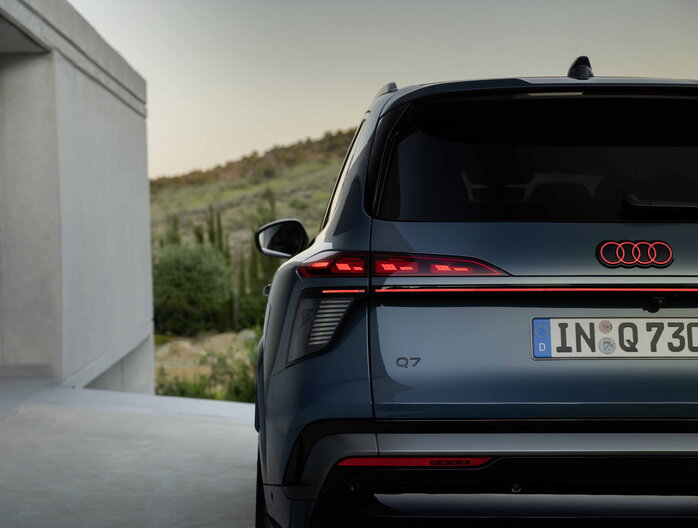 Elegante achterkant van de donkerblauwe Audi Q7 met kenmerkende achterlichten.