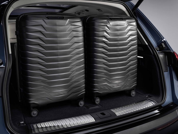 De donkerblauwe Audi Q7 onthult een royale kofferbak, efficiÃ«nt gevuld met twee grote koffers.