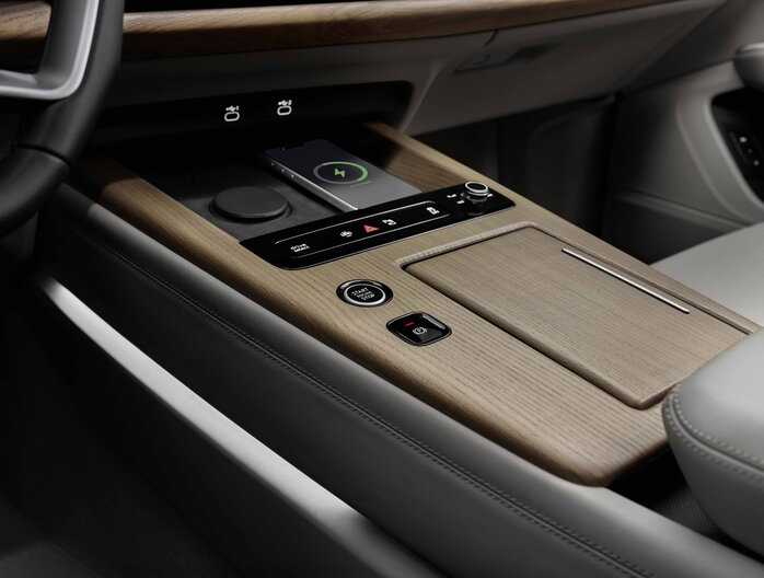 Audi Q7 middenconsole met houten afwerking, draadloos opladen en startknop.