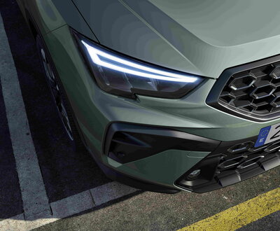 Groene Seat Arona SUV met heldere LED-dagrijverlichting en opvallende grille-details.