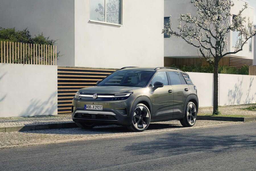 Donkergroene Volkswagen Id.Cross parkeert stijlvol voor modern huis op zonnige straat.