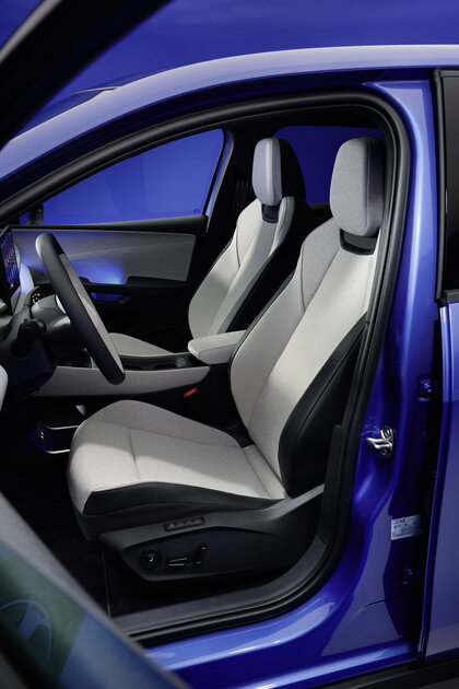 Interieur van de blauwe Volkswagen ID.Polo met lichte, comfortabele stoffen stoelen en modern stuur.