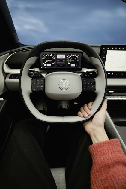 Volkswagen Id.Polo interieur met bestuurdershand aan het stuur en digitaal dashboard display.
