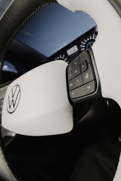 Het witte stuurwiel van de Volkswagen ID.Polo met bedieningsknoppen en merklogo.