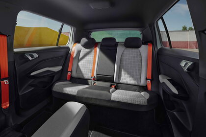 Ruime achterbank van de Škoda Epiq met opvallende oranje veiligheidsgordels en comfortabele stoelen.