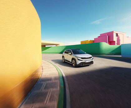 Škoda Epiq compacte elektrische SUV navigeert een bocht in een levendige stedelijke omgeving.