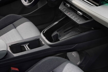 Vooraanzicht van de Škoda Epiq middenconsole met draadloze oplaadpad en bekerhouders.