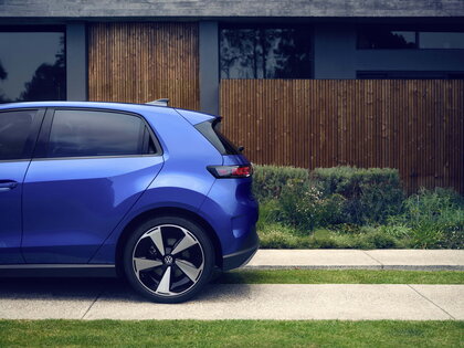 Blauwe Volkswagen Id.Polo elegant geparkeerd naast een moderne architectonische woning.