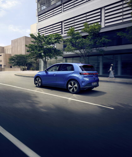 Blauwe Volkswagen ID.Polo rijdt dynamisch door de stad op een zonnige dag.