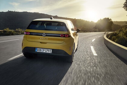 Gele Volkswagen ID.Polo rijdt op een landweg tijdens zonsondergang.