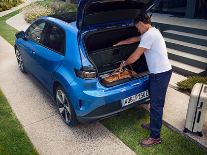 Man laadt bagage in de ruime kofferbak van een blauwe Volkswagen ID.Polo.