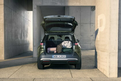 Achteraanzicht van de groene Volkswagen ID. Cross met de open kofferbak vol bagage.