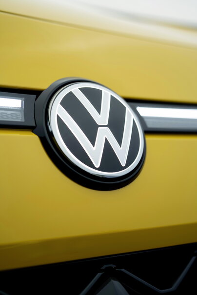 Close-up van het VW-logo op de gele Volkswagen T-Roc met LED-lichtstrip