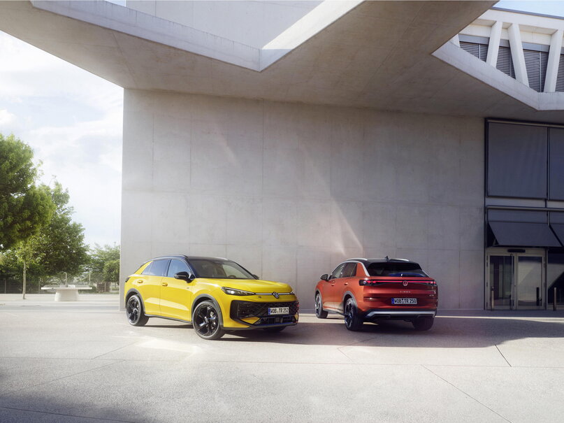 Gele en oranje Volkswagen T-Roc R-Line geparkeerd bij een modern gebouw.