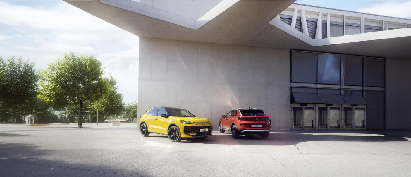 Gele en oranje Volkswagen T-Roc geparkeerd voor een modern gebouw.