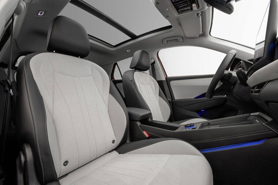 Interieur van de Volkswagen T-Roc met witte stoelen en panoramisch schuifdak.