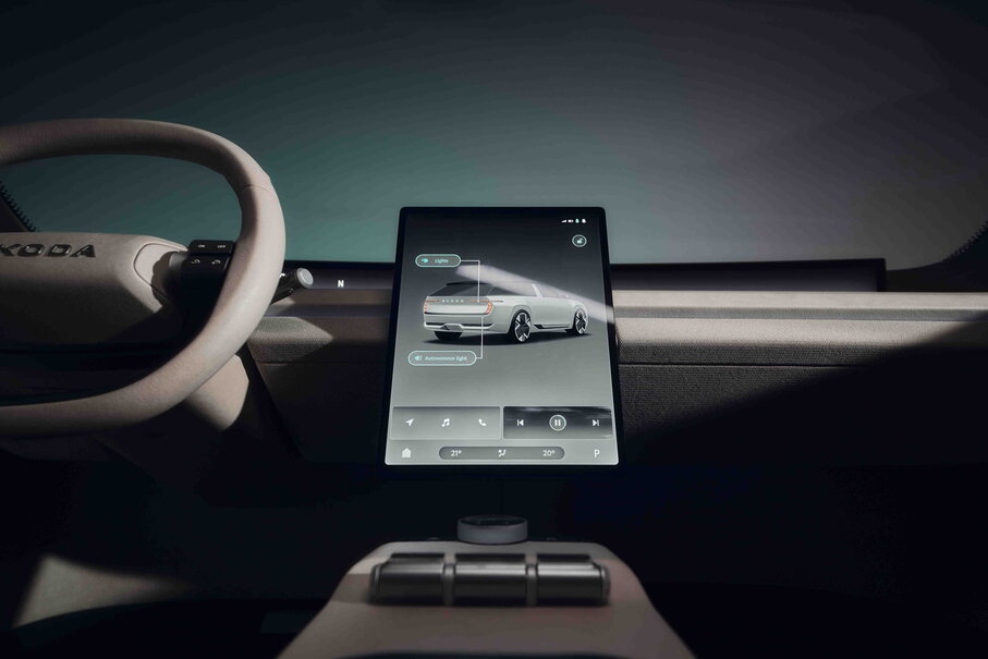 Skoda Vision O interieur met beige stuurwiel en centraal touchscreen. Het scherm toont een witte auto.