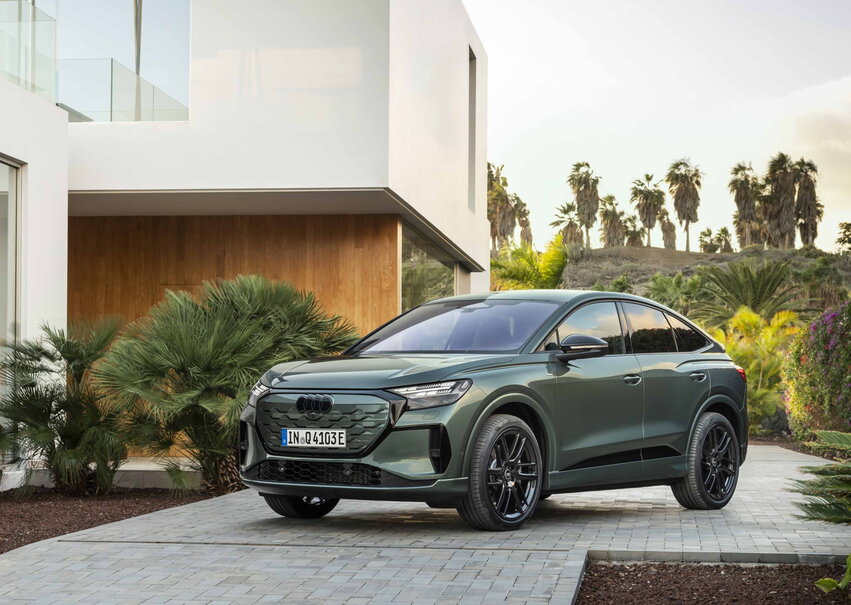 Donkergroene Audi Q4 Sportback e-tron elektrische SUV met zwarte velgen buiten.