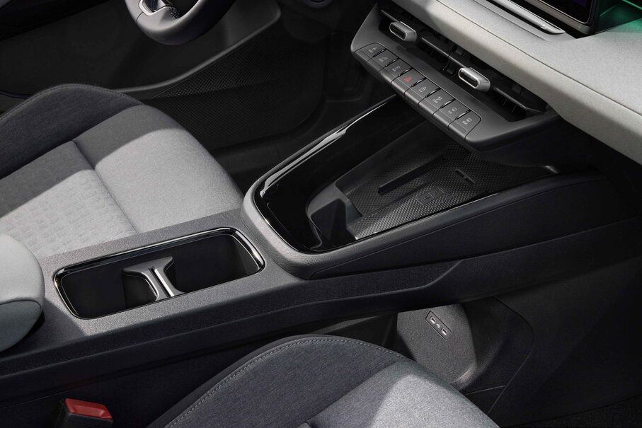 Vooraanzicht van de Škoda Epiq middenconsole met draadloze oplaadpad en bekerhouders.