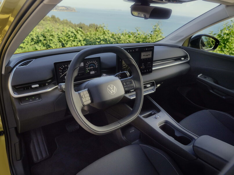 Interieur van gele Volkswagen ID.Polo met digitaal dashboard en uitzicht op zee.