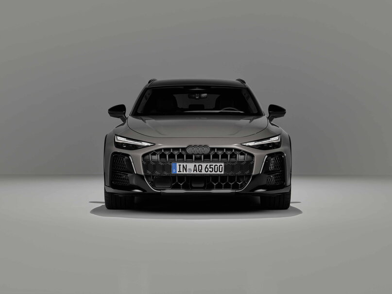 Audi A6 Allroad grijs, strak vooraanzicht met kenmerkende koplampen in studio.