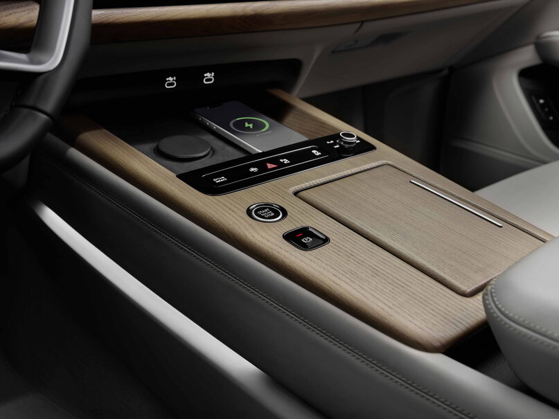 Audi Q7 middenconsole met houten afwerking, draadloos opladen en startknop.