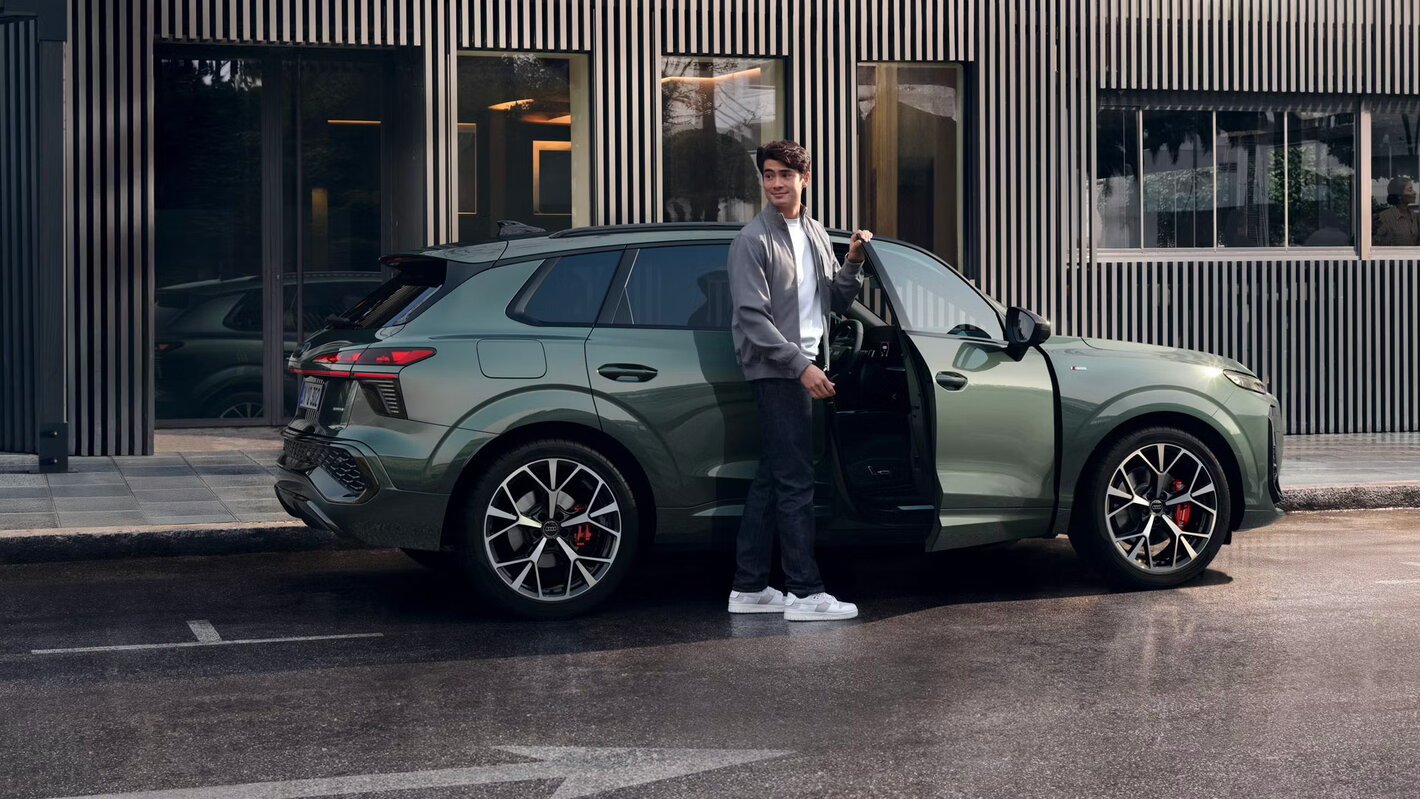 nieuwe audi Q3 2025 groen zijaanzicht met jongeman in stad