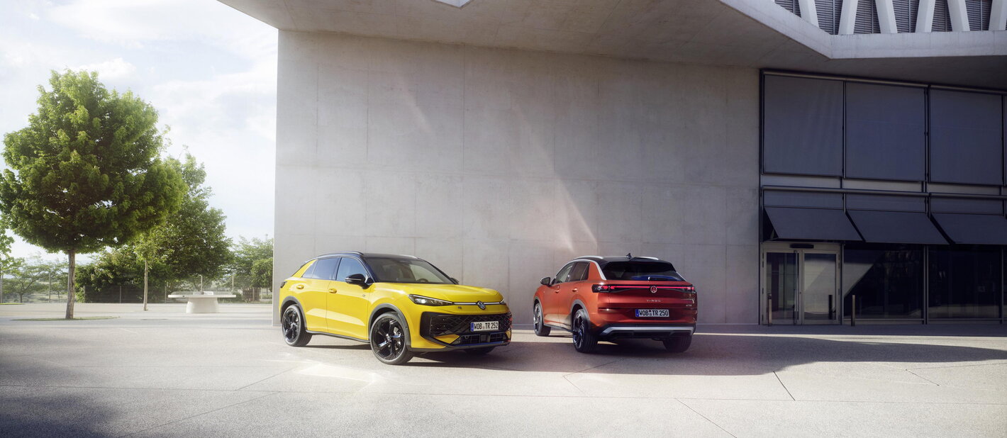 Gele en oranje Volkswagen T-Roc naast elkaar geparkeerd voor een modern gebouw