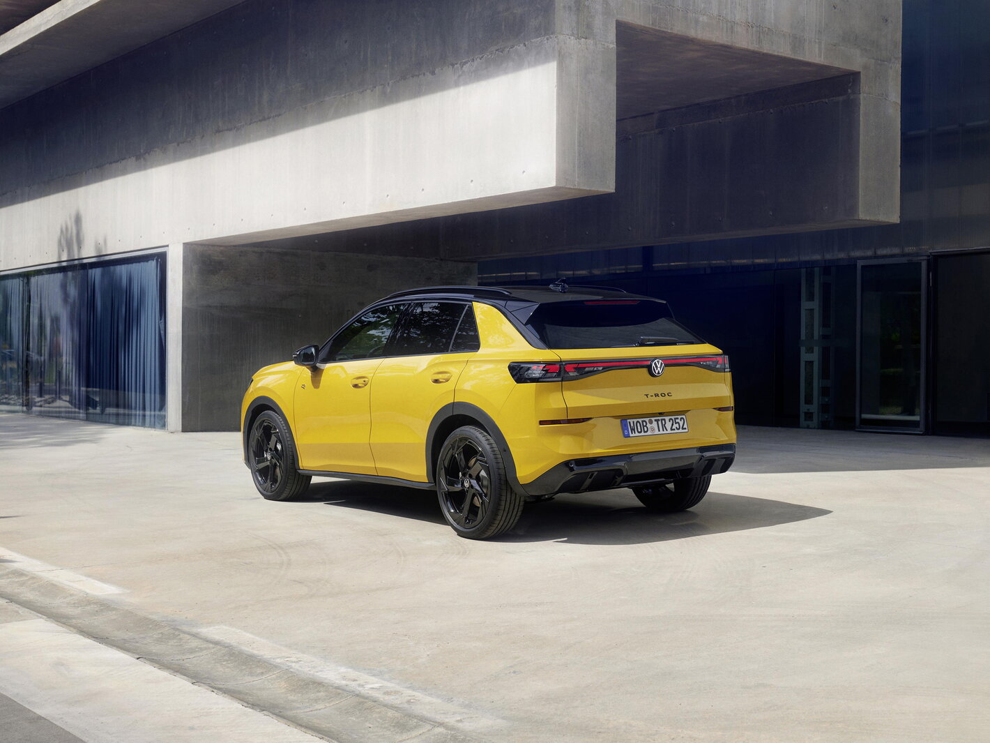 Achterzijde van de gele Volkswagen T-Roc met zwarte accenten en LED-lichten