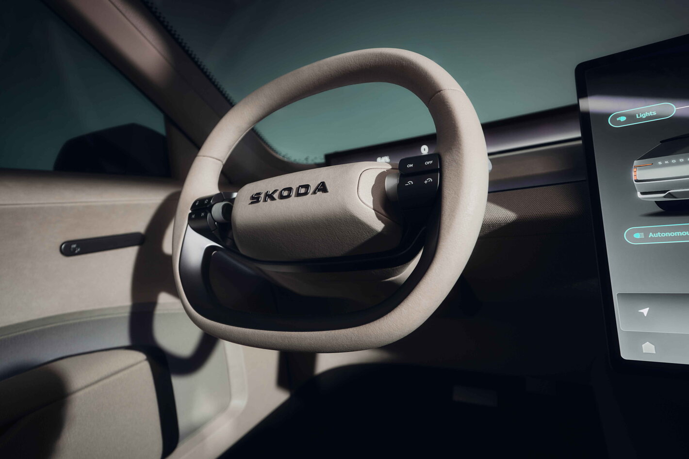 Skoda Skoda Vision O interieur met modern beige stuurwiel en groot digitaal infotainmentscherm.