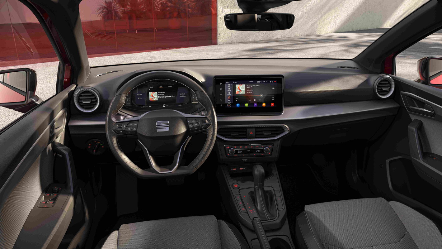 Moderne zwarte interieur van de Seat Ibiza, inclusief stuurwiel en groot centraal touchscreen.