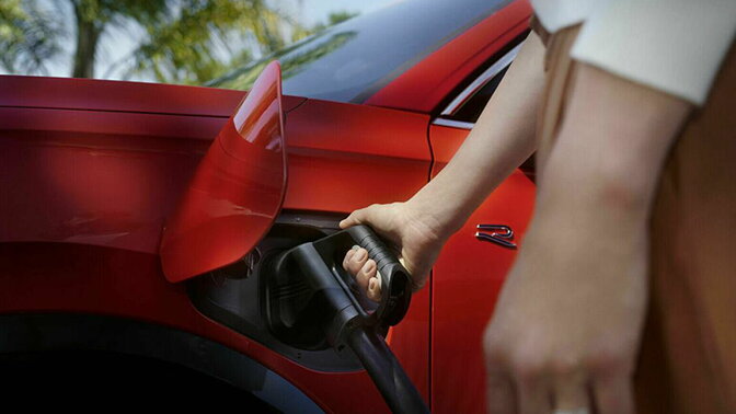 Volkswagen PHEV persoon plugt laadkabel in auto