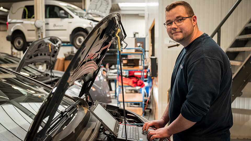 Volswagen Technieker werkt aan wagen met laptop in de werkplaats