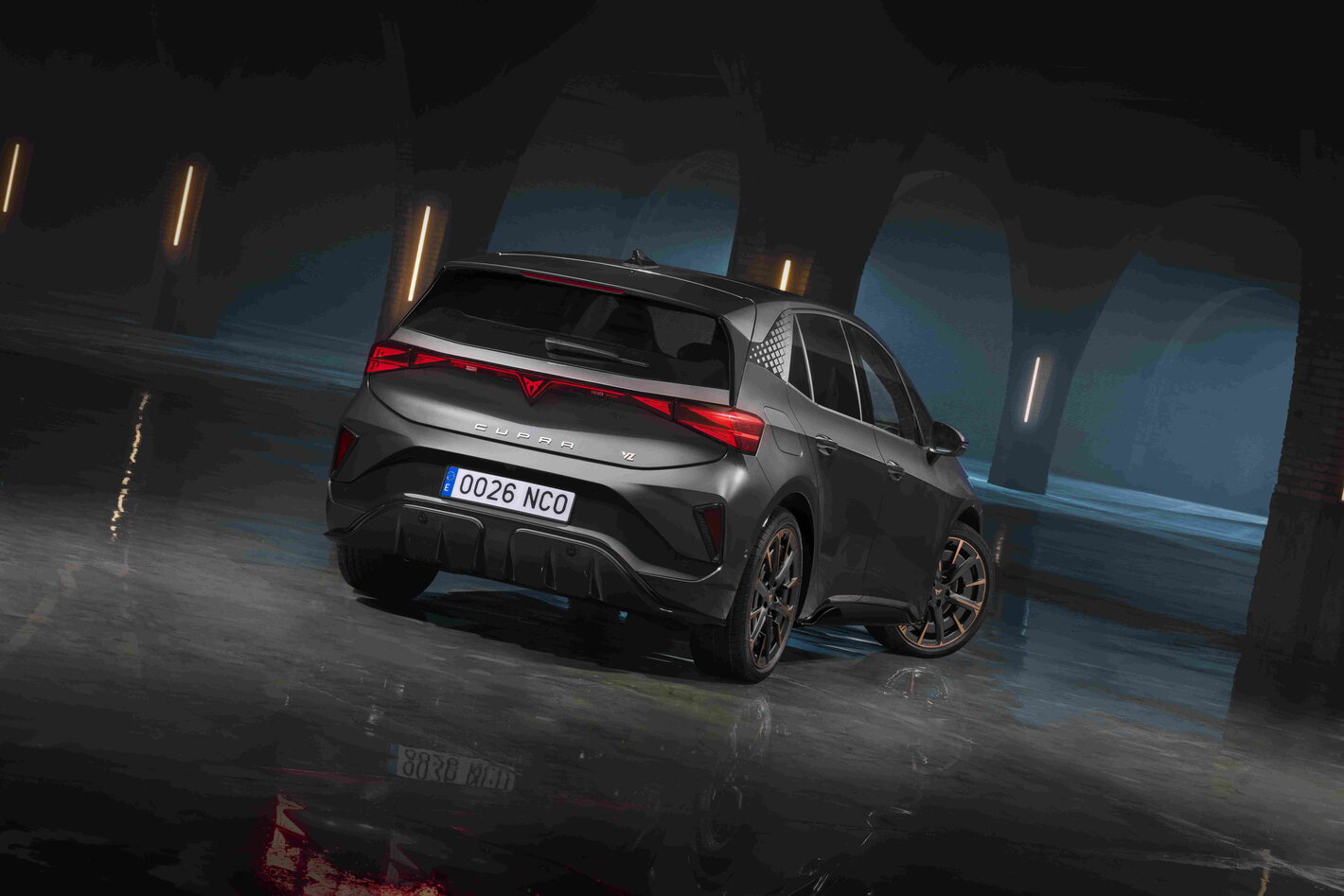 Achterkant donkergrijze Cupra Born met sportief design en opvallende rode LED-achterlichten.