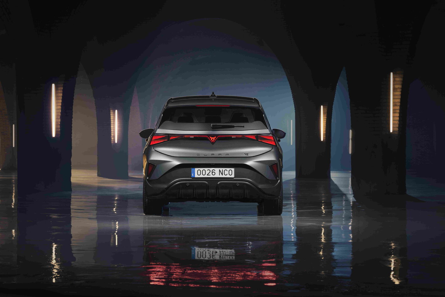 Achterkant van een donkergrijze Cupra Born met opvallende LED-achterlichten in een sfeervolle tunnel.