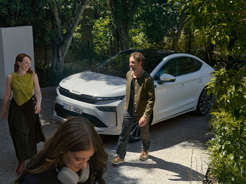 witte skoda enyaq coupé met gezin die net uitgestapt is