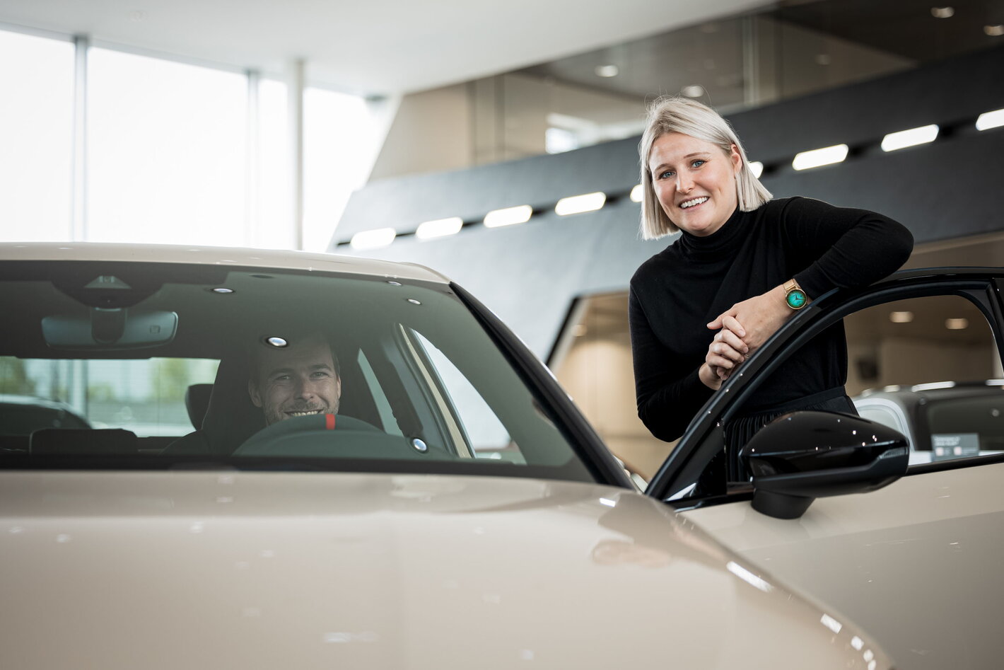 Sales advisor bij Audi Groep Thoen geeft uitleg over een wagen aan een klant die in de wagen zit
